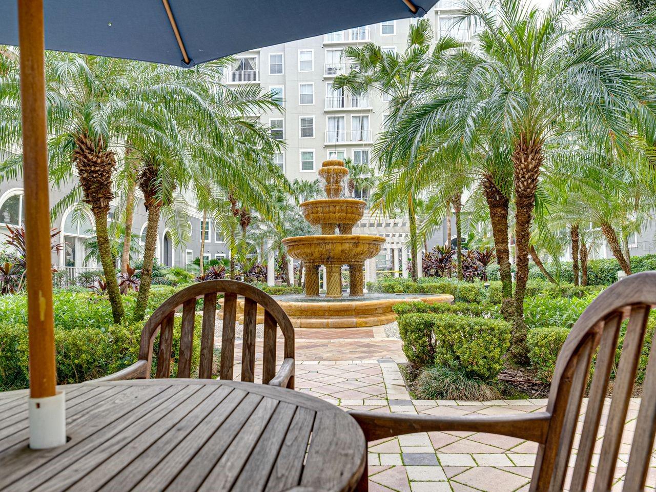 A vibrant tropical courtyard, complete with a fountain, is the ideal spot to relax and unwind.