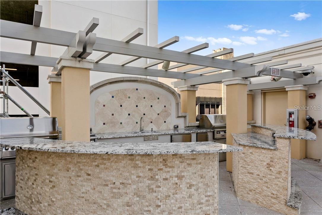Outdoor kitchen has 2 professional style grills, ice maker, sink, refrigerator