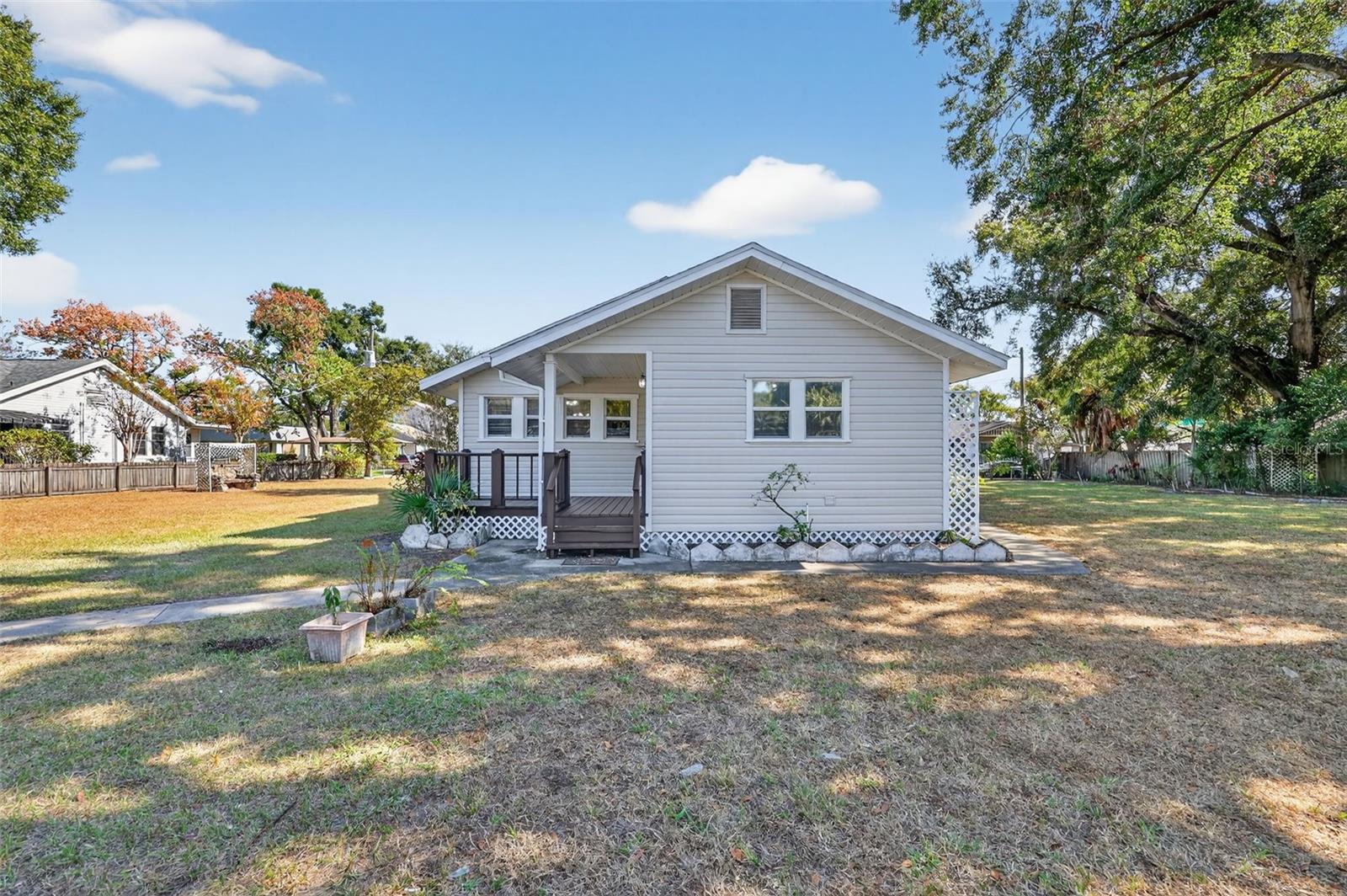 Rear of the home with a sweet back porch and wide open spaces of a full lot on either side