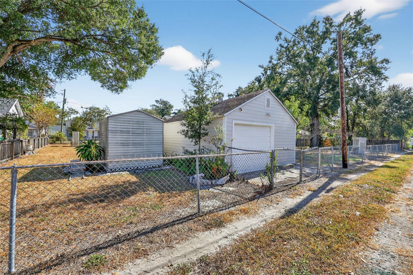 From back alley, viewing shed and detached garage with workshop inside