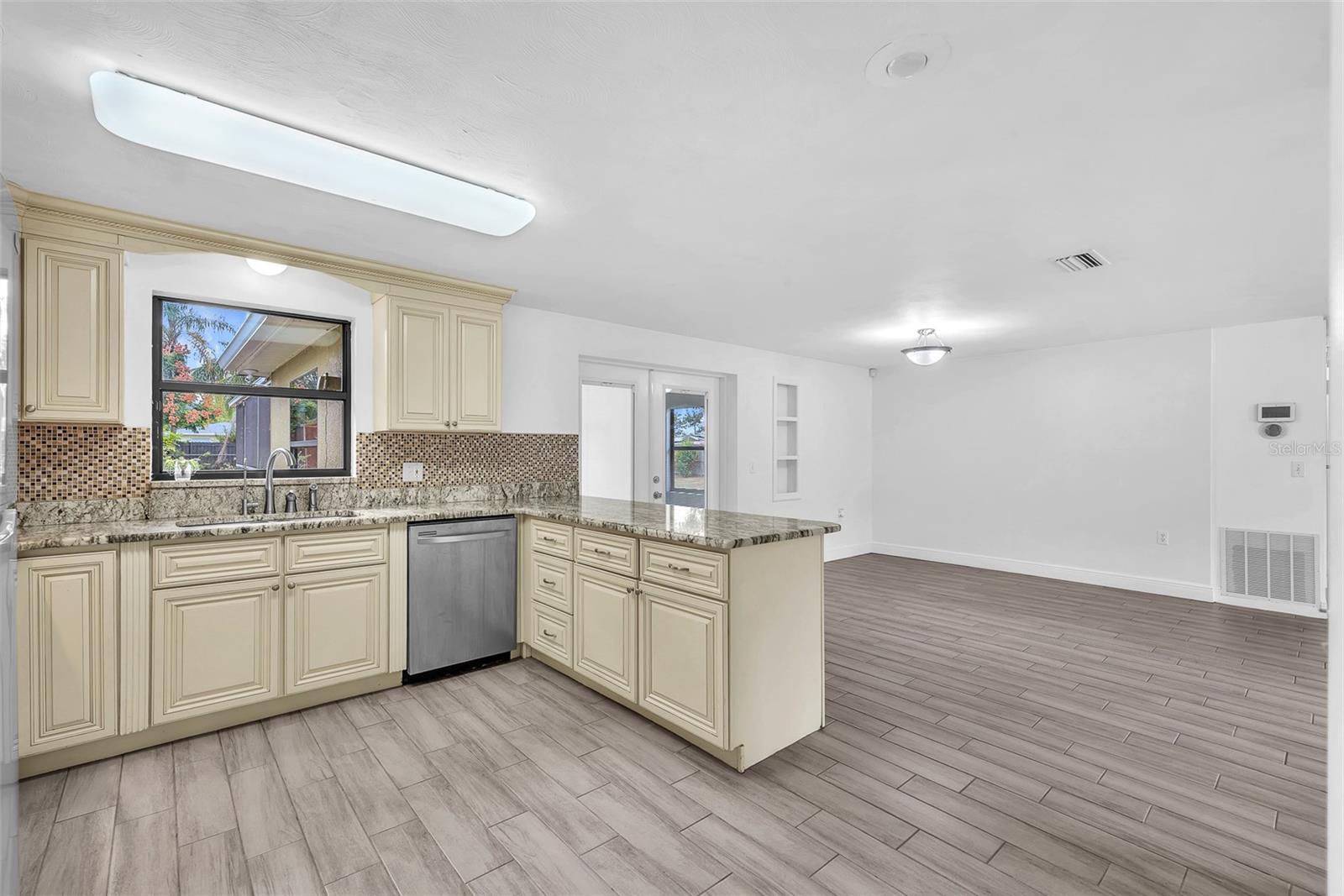 The breakfast bar connects athe kitchen and dining area and french doors flow into a sun-filled Florida bonus room with avaulted ceilings  — ideal flow for relaxing or entertaining.