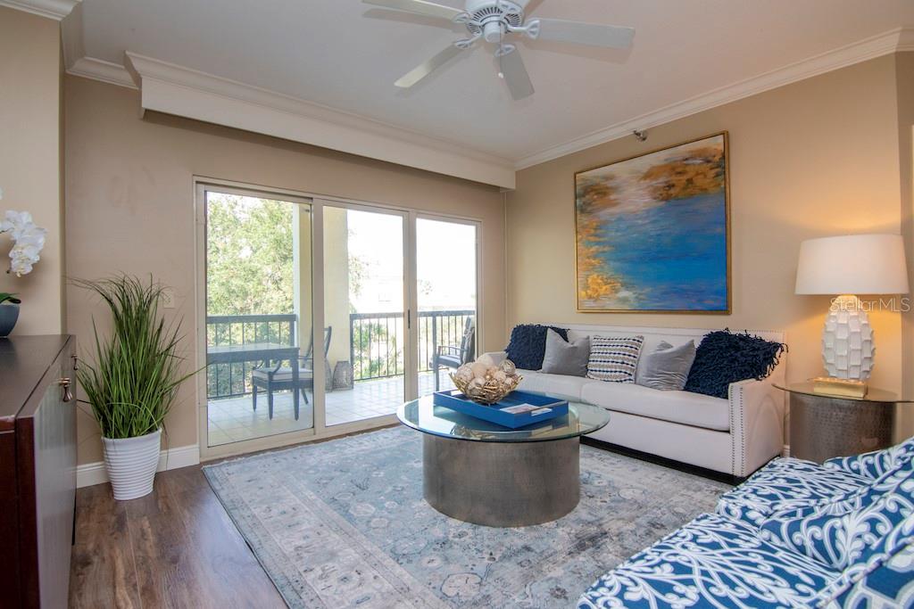 Natural light fills the open living spaces and flows onto an expanded balcony offering morning sun and serene evenings, accessible from the living room, primary suite, and second bedroom.