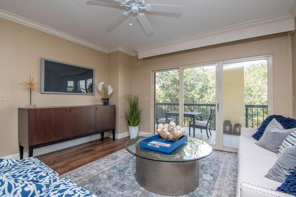 Natural light fills the open living spaces and flows onto an expanded balcony offering morning sun and serene evenings, accessible from the living room, primary suite, and second bedroom.