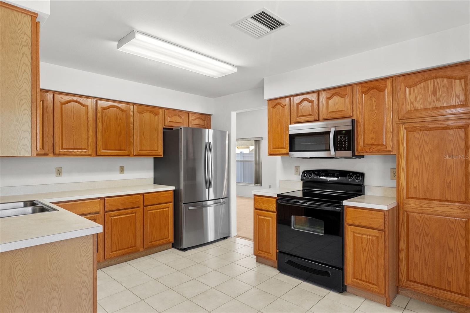 View of kitchen with ample countertops and refinished REAL OAK cabinets.