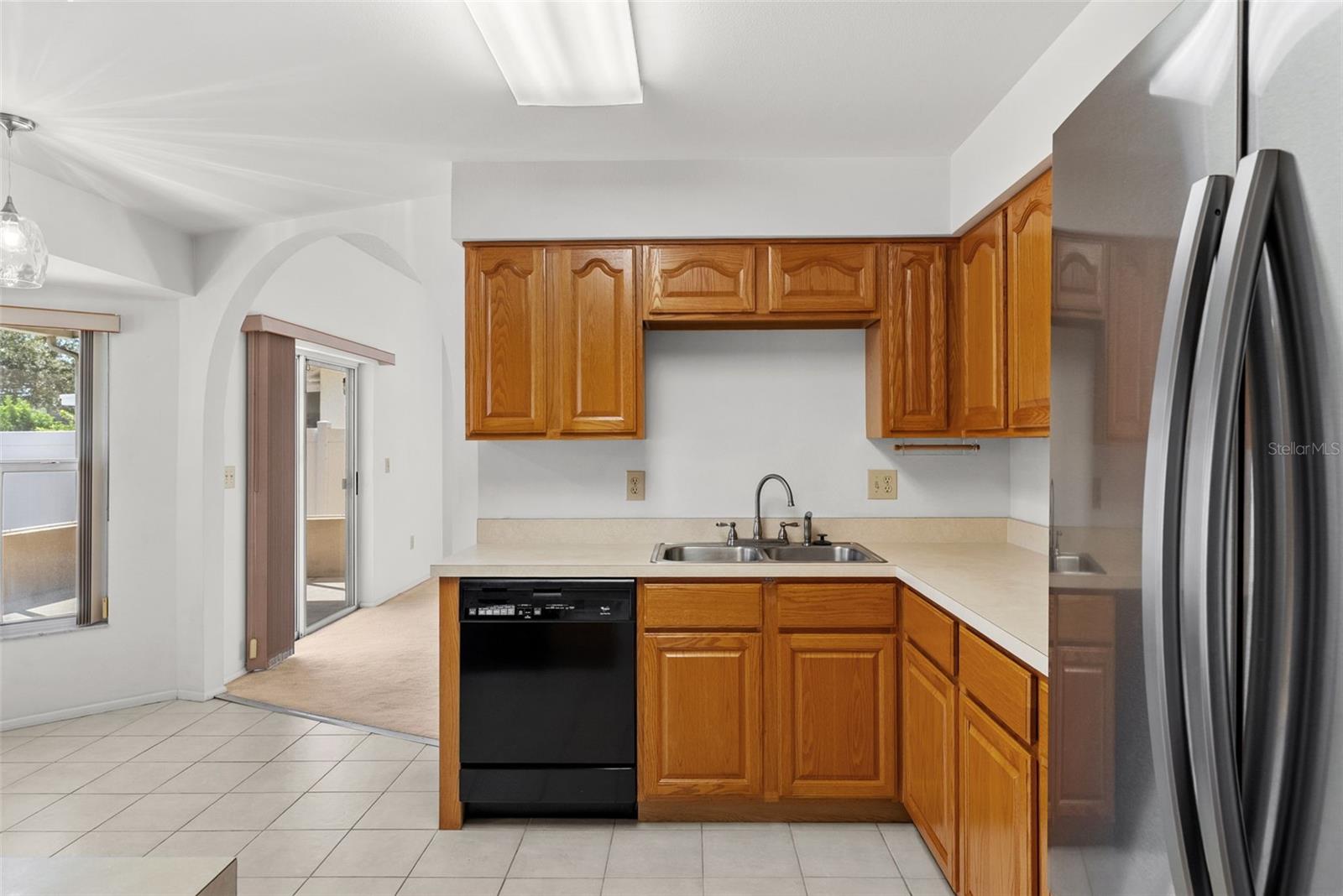 Eat-in kitchen looking toward family room with view of expansive lanai and backyard.