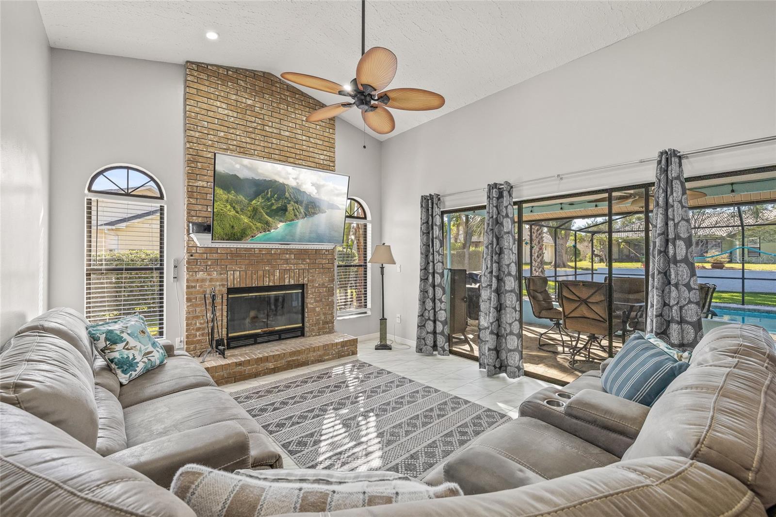 Living room with fireplace and glass sliders to the pool