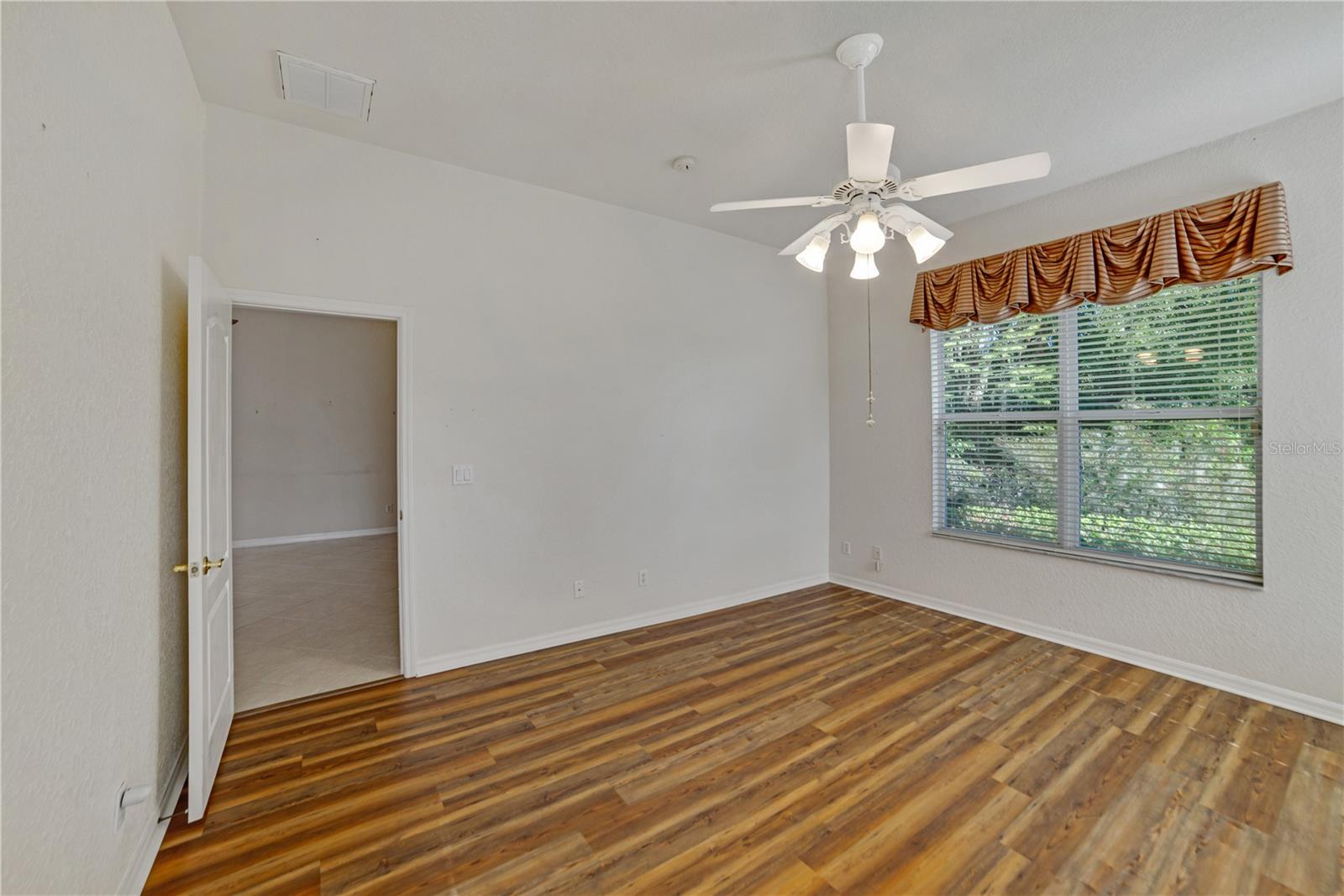 GUEST BEDROOM WITH LAMINATE FLOORING AND CEILING FAN/LIGHT
