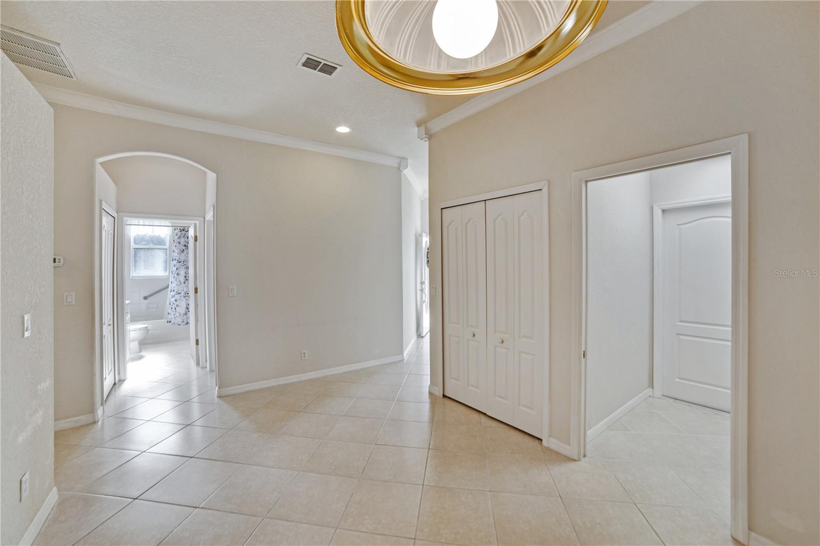 WIDE HALLWAY SEPARATES DINING/FLEX AREA FROM DEN AND GUEST AREAS.  LOVELY CERAMIC TILE IN THE HIGH TRAFFIC AREAS