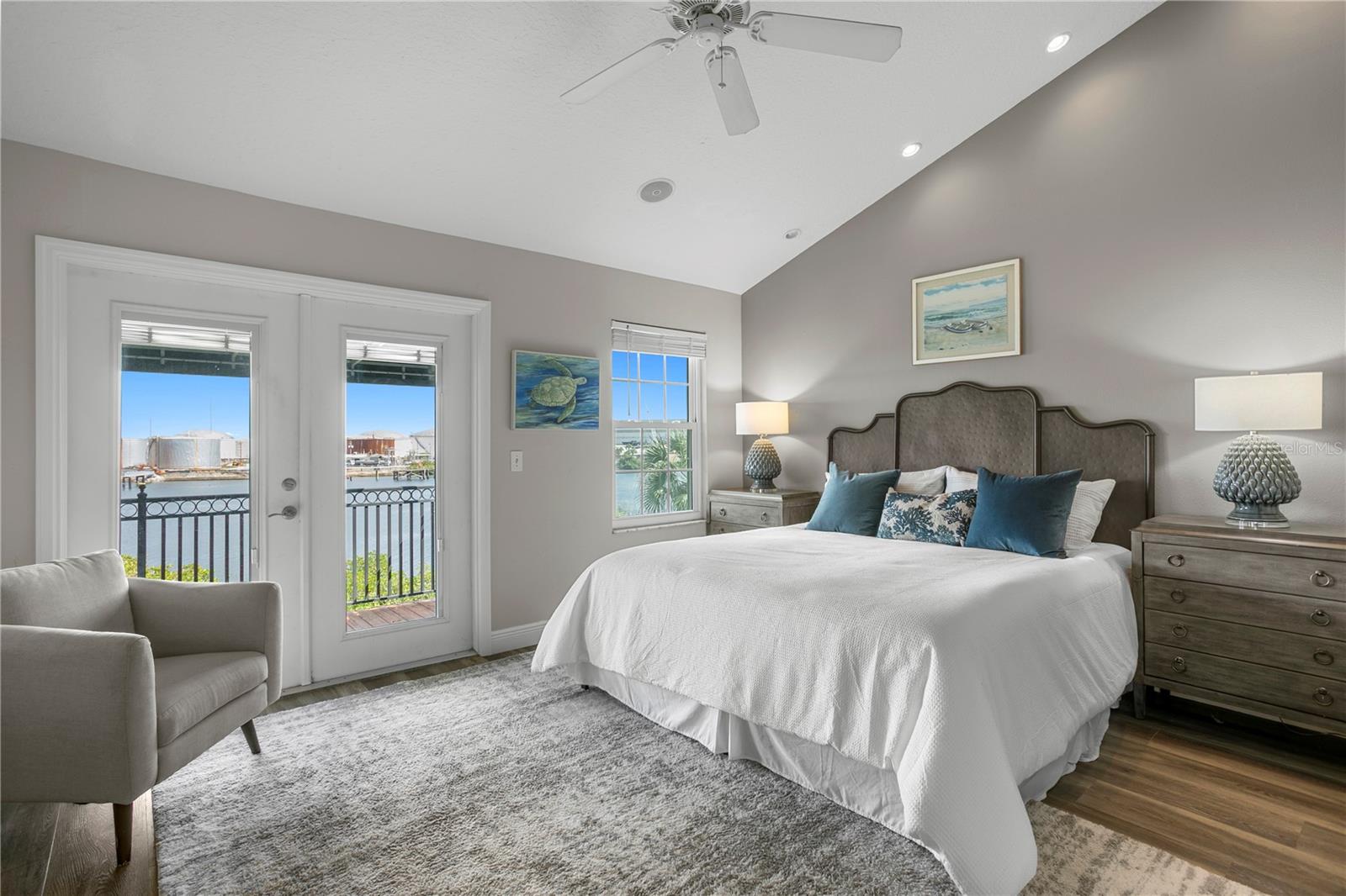 The serene primarysuite boasts channel views from bed, a custom walk-in closet, and a spa-inspired bathwith dual vanities, light wood cabinetry, and a soaking tub.