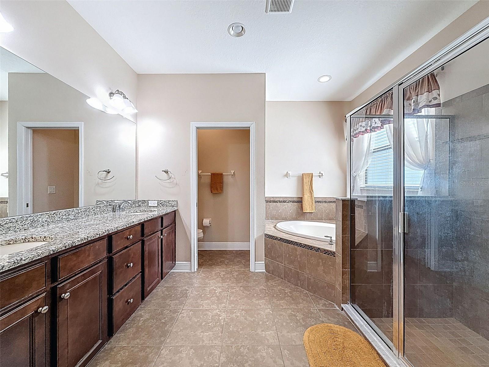 Duel vanities, gorgeous GRANITE countertops, walk in shower and raised garden tub