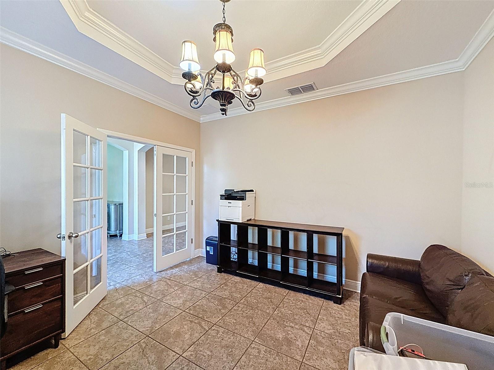 Extra large office with crown molding and neutral tile and paint. Could easily be a 5th bedroom!