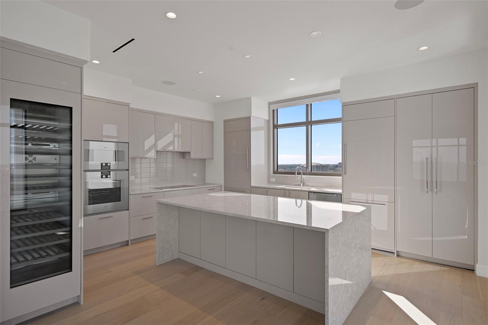 Dual refrigerators, dual freezers, wine fridge. Sleek cabinetry with hidden panel fridge design.