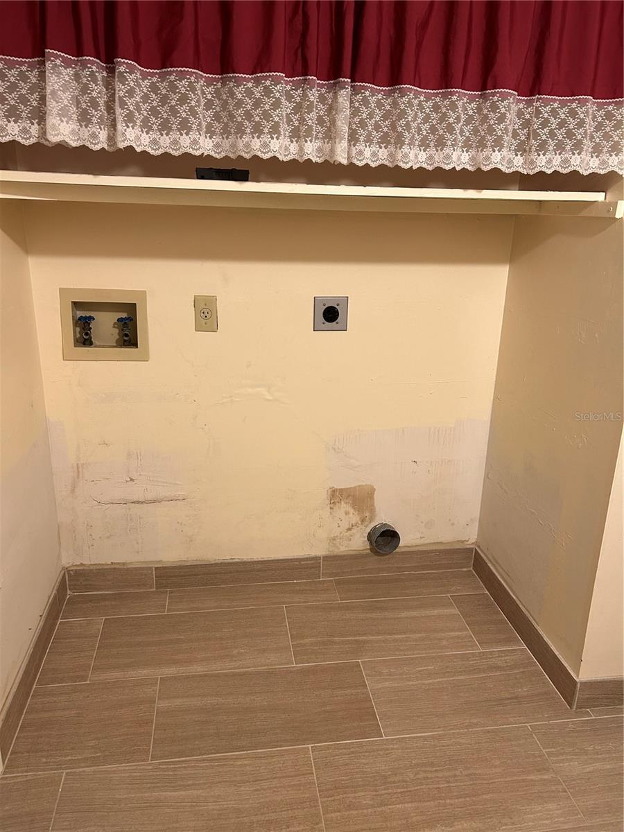 Wash/Dryer hookup area with shelf above