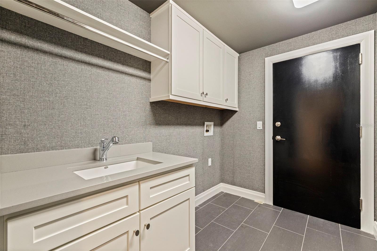 Laundry and utility room with designer wallpaper throughout.