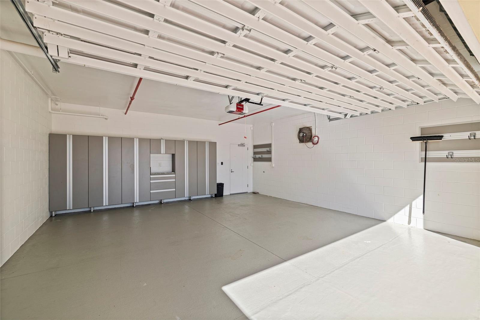 Spacious 2 Car garage with custom built-in cabinets.