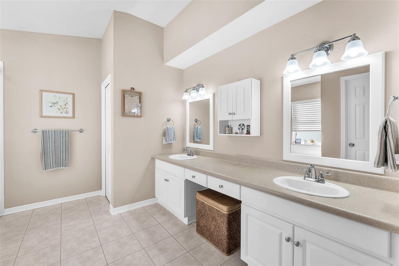 The primary bath has a large vanity with plenty of storage and dual sinks.