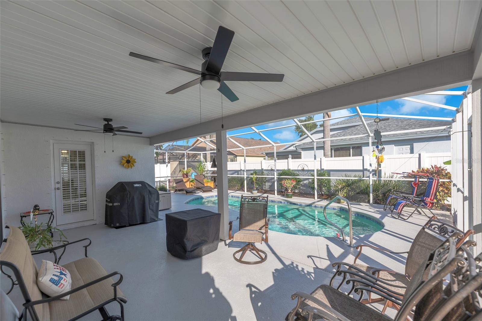 The covered back porch features a maintenance-free ceiling and upgraded ceiling fans for comfort year-round and access to the guest bathroom.