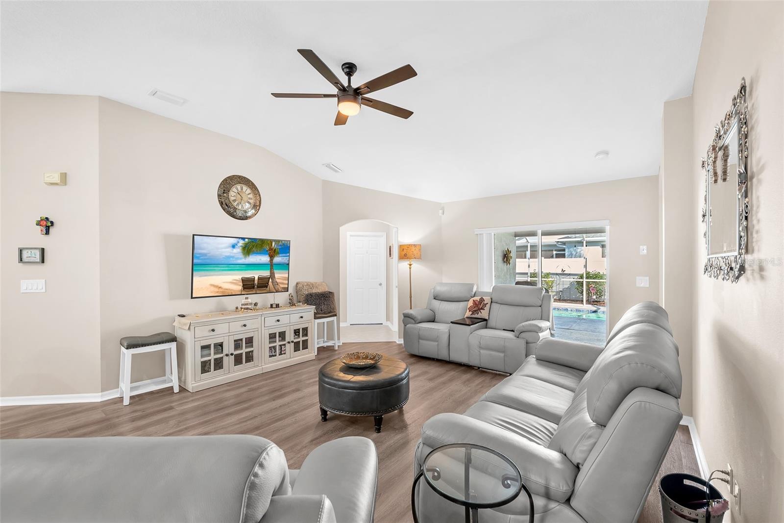 Spacious great room with LVT floors, soaring ceilings, and seamless flow to the poolside lanai.