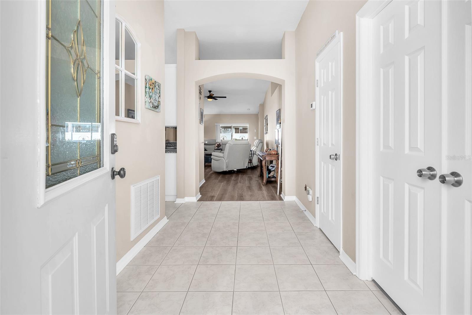 An impressive leaded-glass entry door opens to a refined tiled foyer, creating a grand first impression.