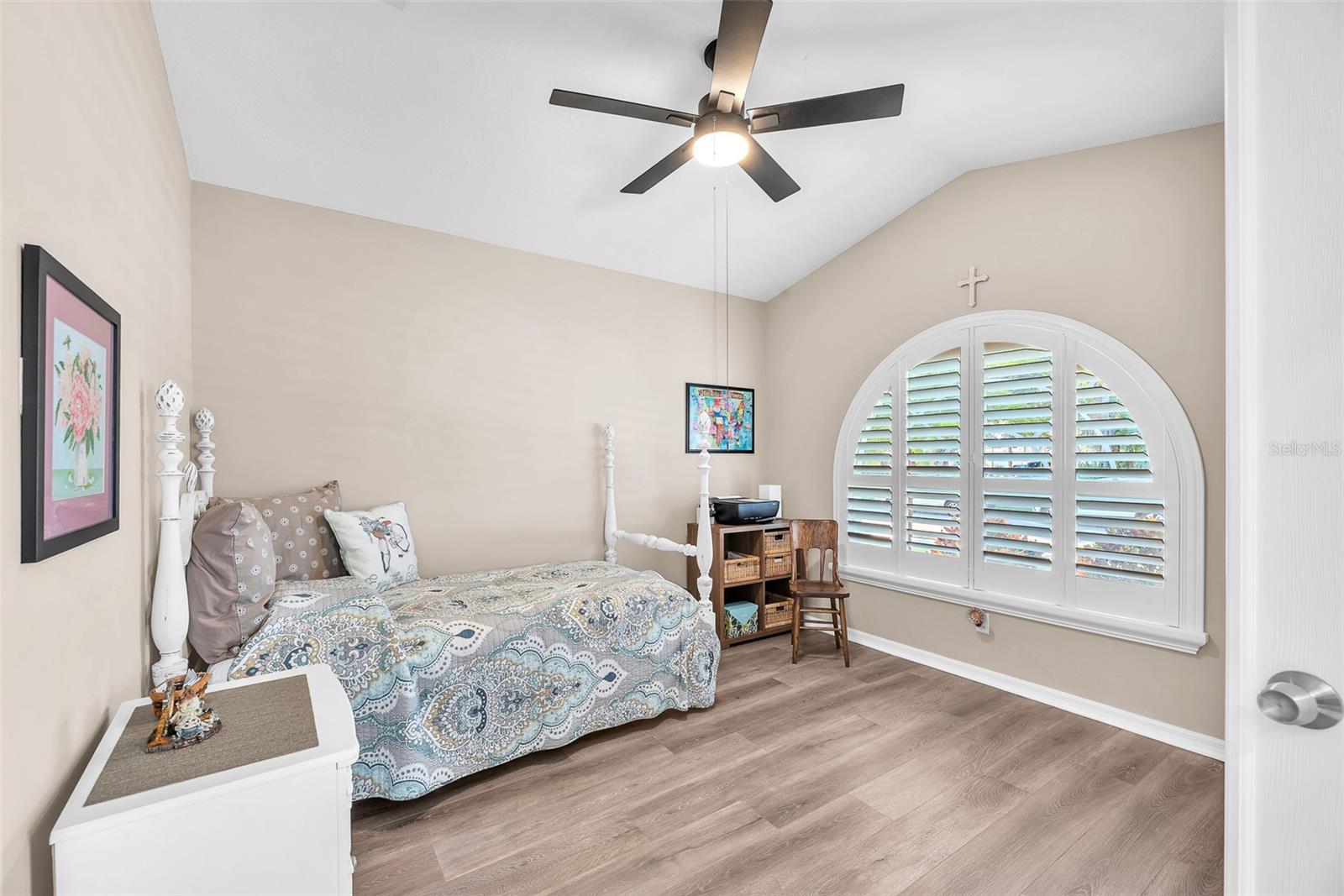 The front office or den is to the right of the tiled foyer and has a vaulted ceiling and plantation shutters.