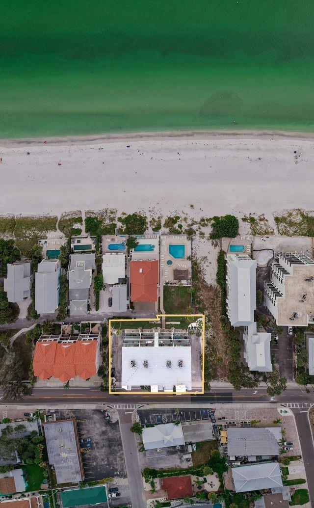 Overview of building, lawn area and pool to beach front.
