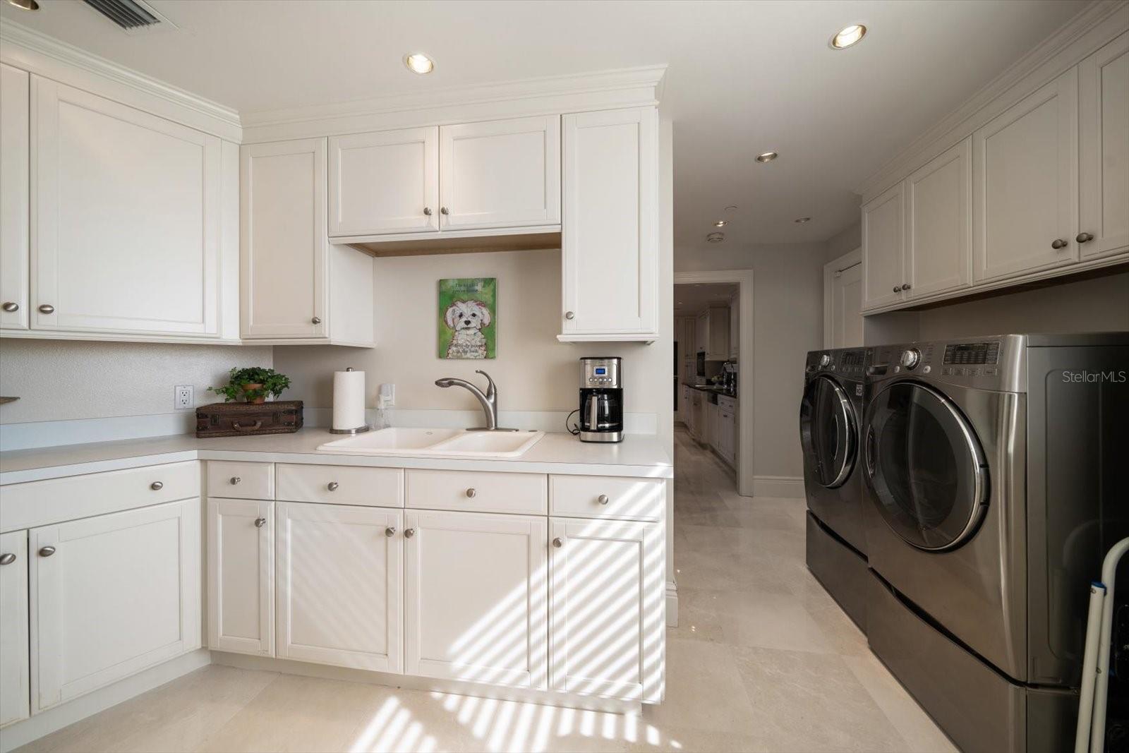Butler's pantry area is accessible from the main kitchen and dining areas, and provides an essential hidden space for staging meals, additional storage and convenience to the laundry area.