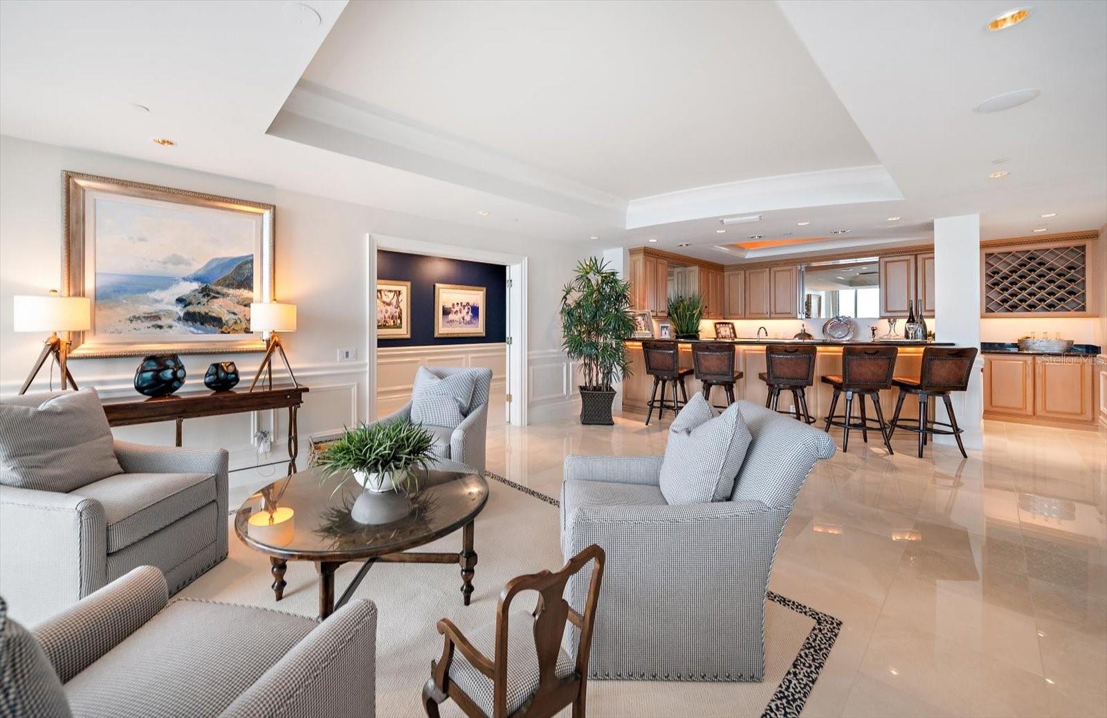 A sitting area and a wet bar enhance the versatility of use throughout the living spaces found on this full-floor estate.
