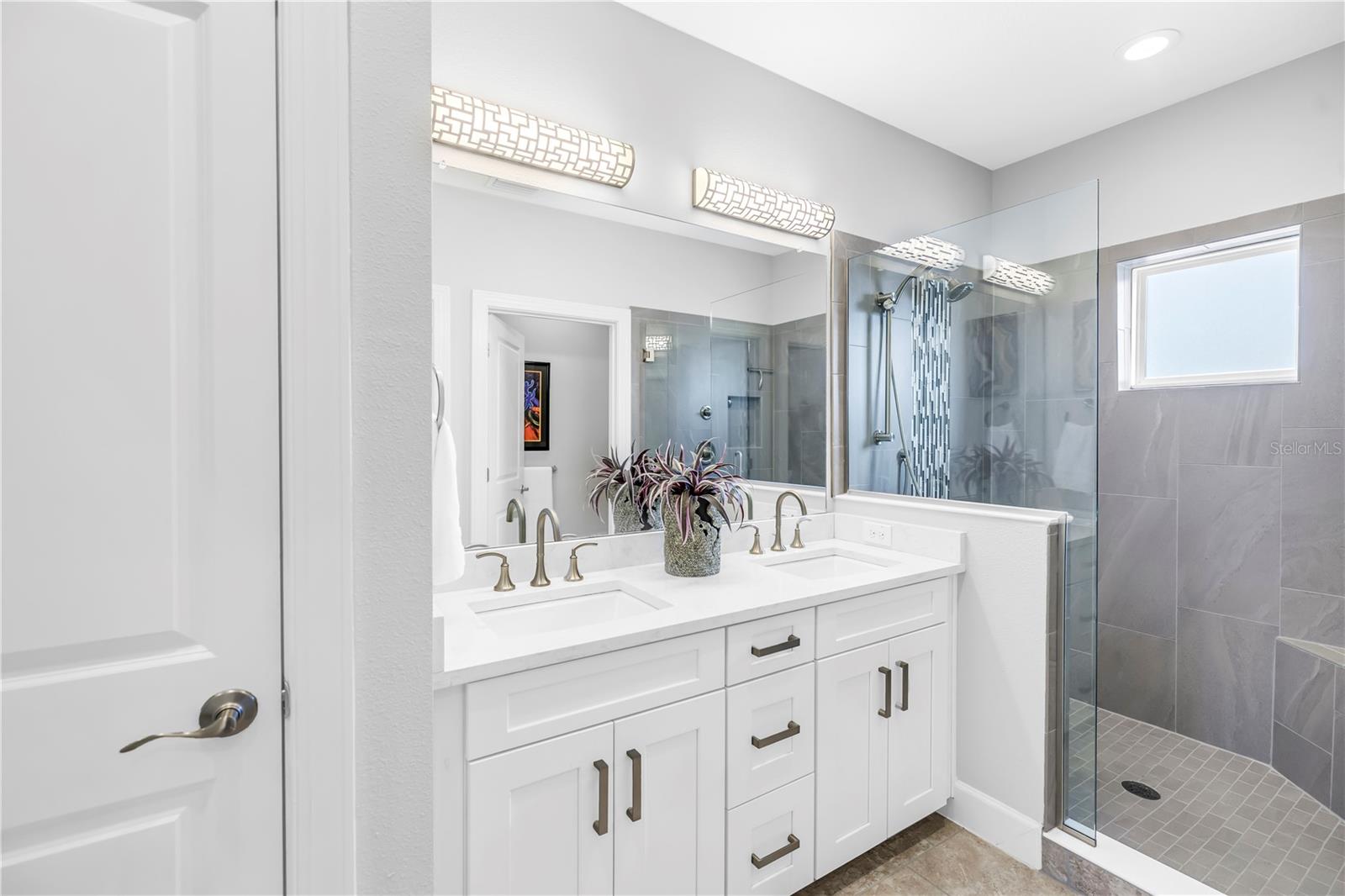 Primary Bathroom with double vanity and seamless shower