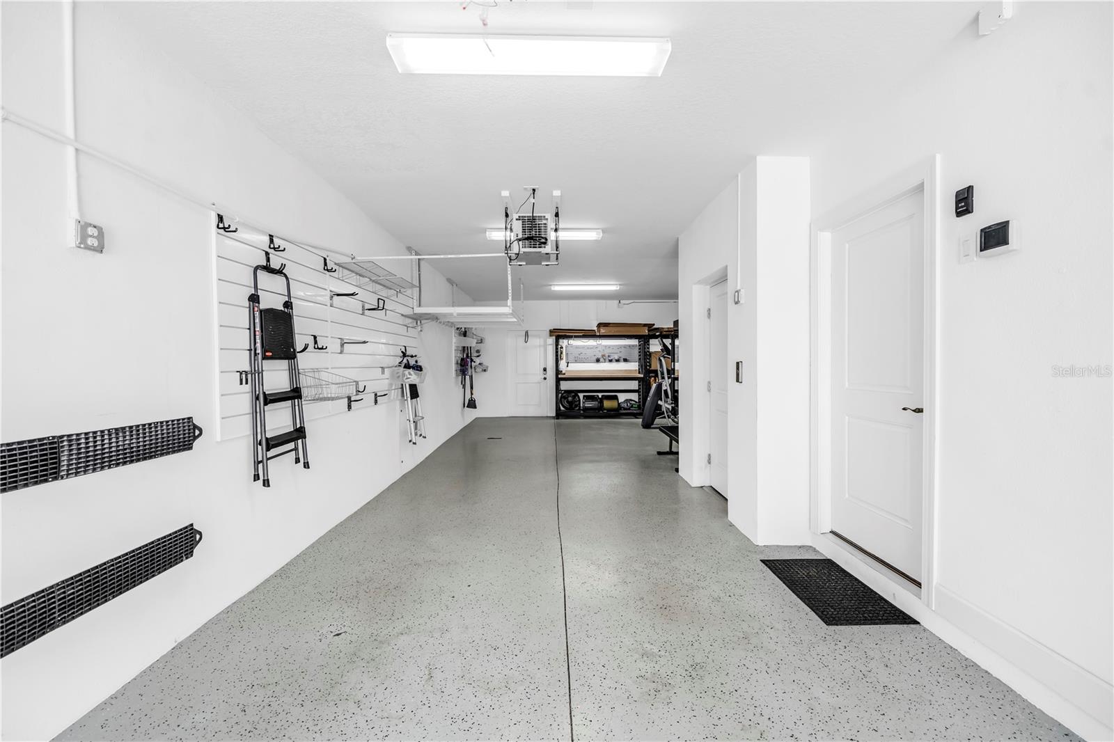 Tandem garage with overhead storage racks and slat wall storage