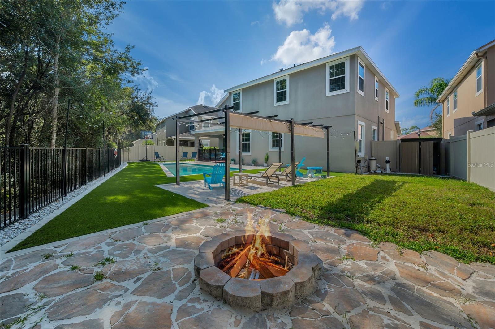 rear of home, fire pit, beach area pergola, lanai, shed, and pool pump