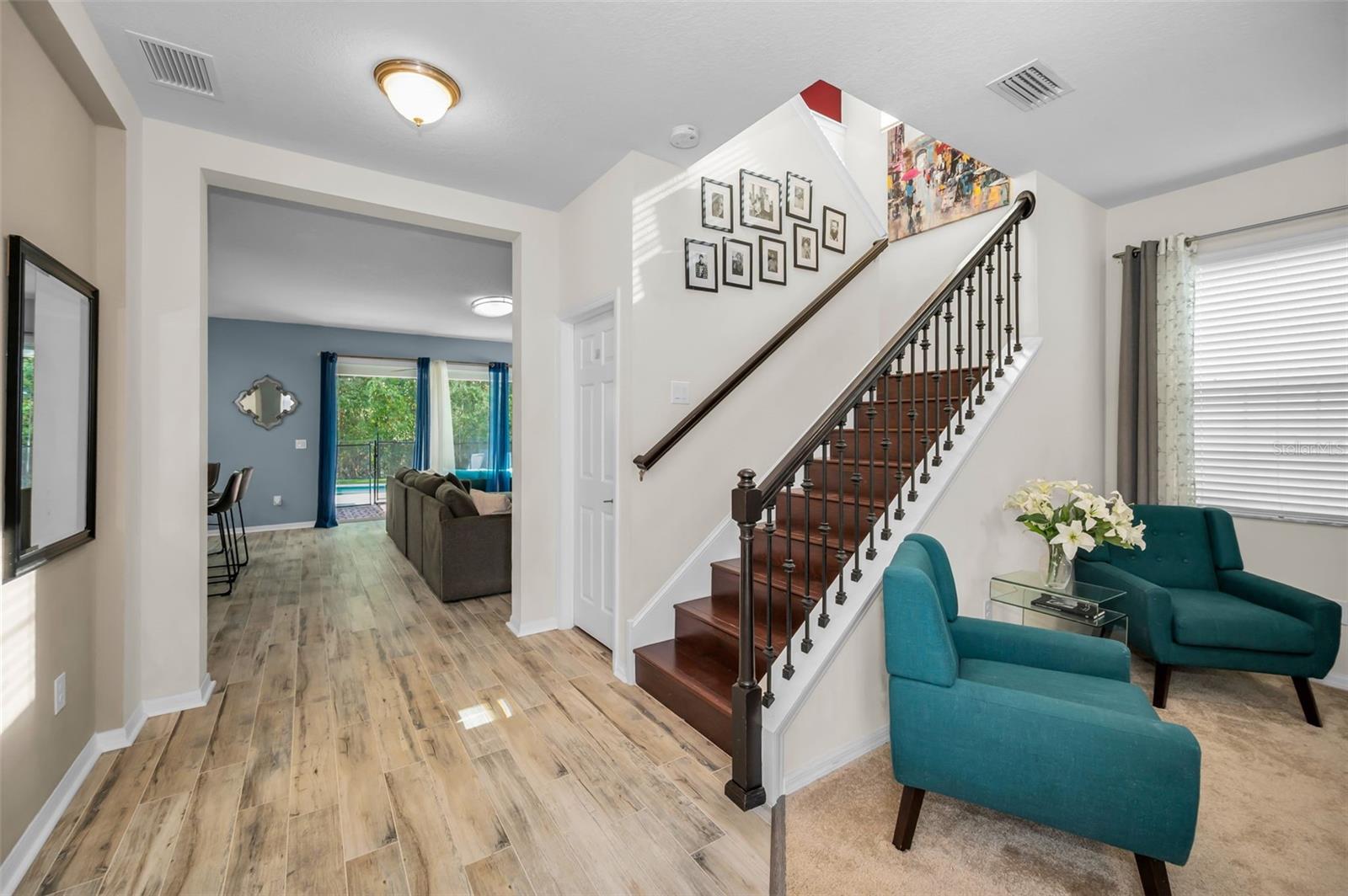looking from entrance w/ living room to the right, stair case, and family room straight ahead