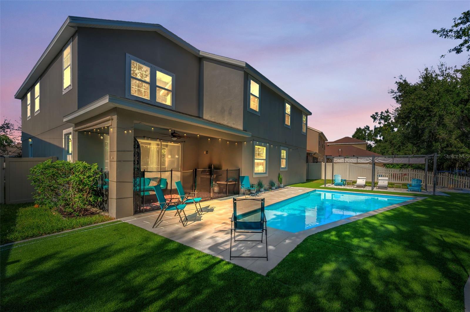 rear of home, lanai, pool, and beach area pergola-twilight