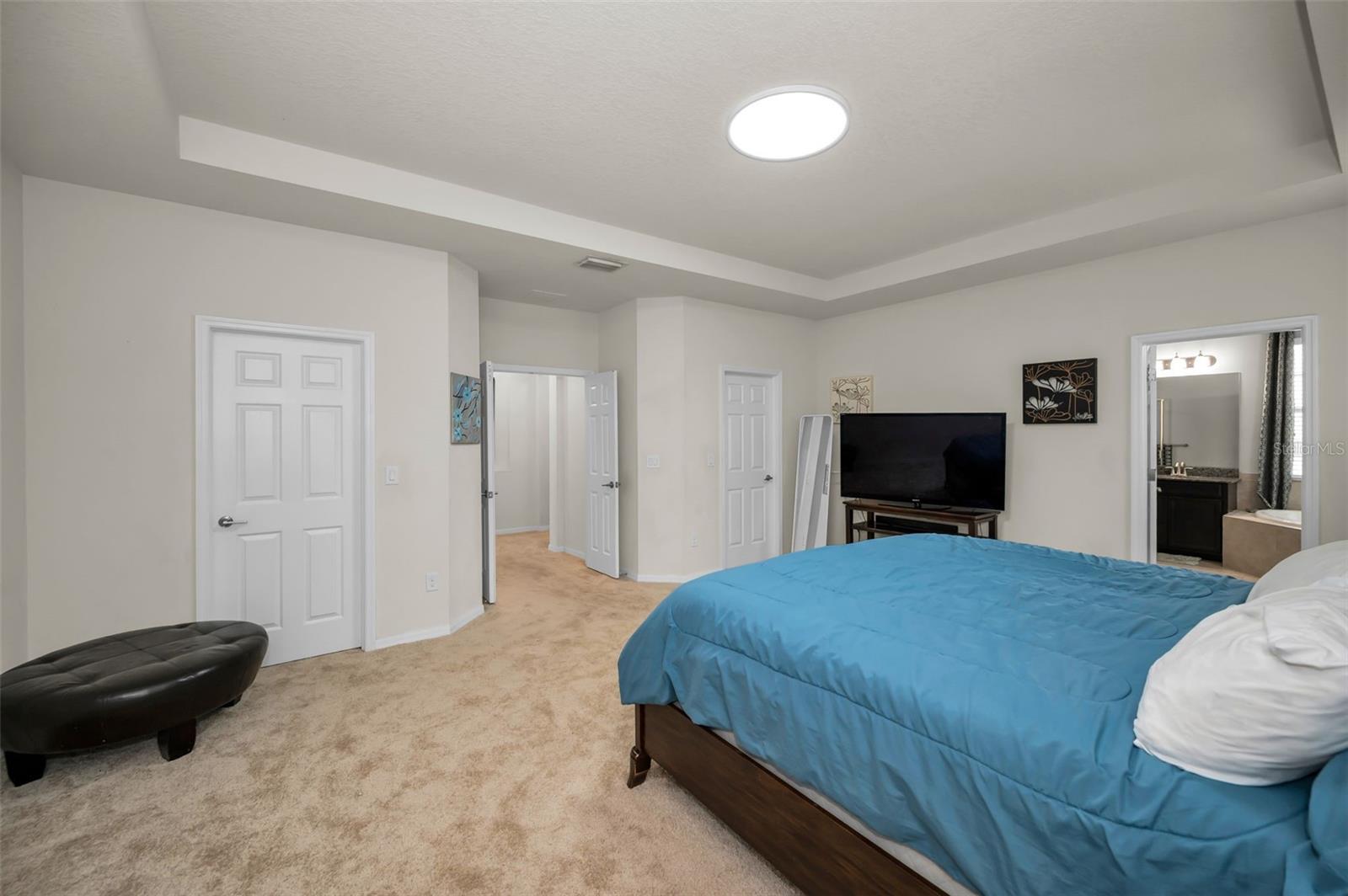primary master bedroom w/ 2 walk-in closets and the entrance to the primary master bathroom