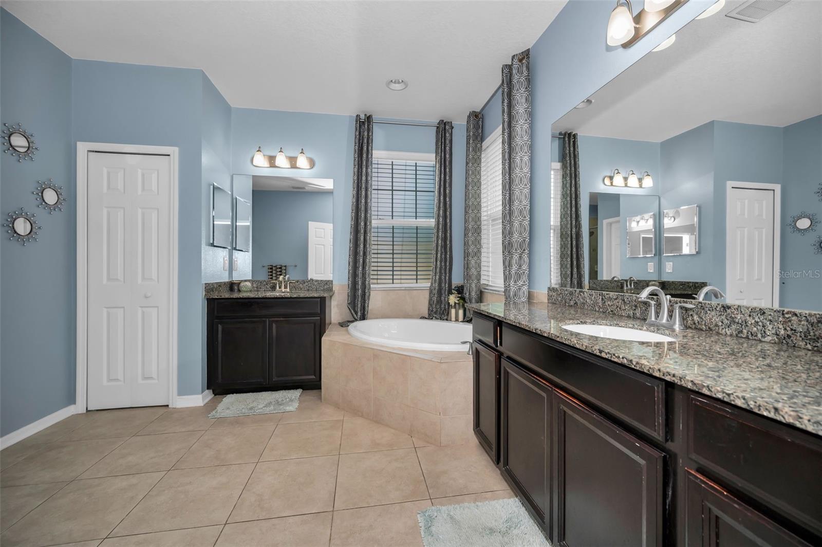 primary master bathroom w/ tub, double vanity/sinks, and water closet