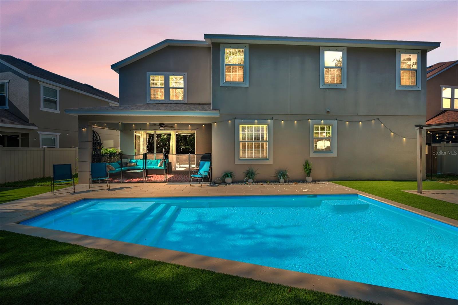 rear of home, lanai, and pool-twilight