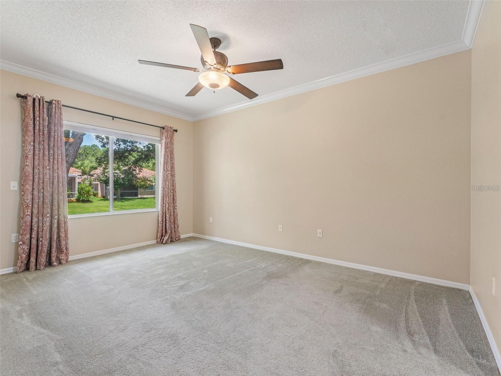 Spacious primary bedroom with large window allowing natural lighting to pour in