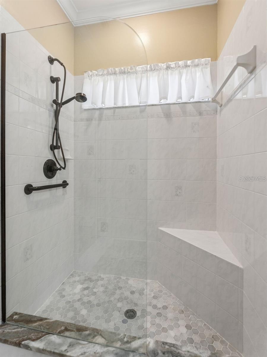 Remodeled shower with bench and glass wall