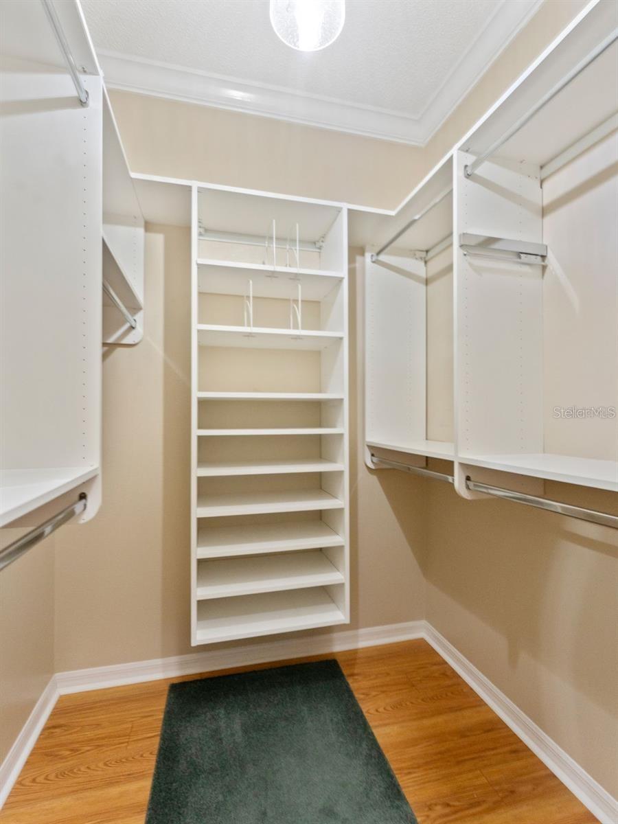 Large walk in closet with custom built in shelving and storage