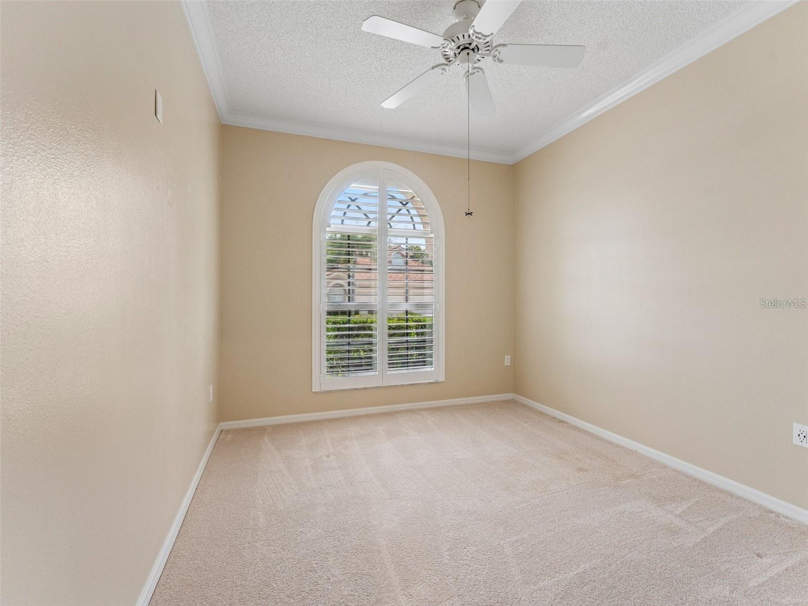3rd bedroom with large window and plantation shutters