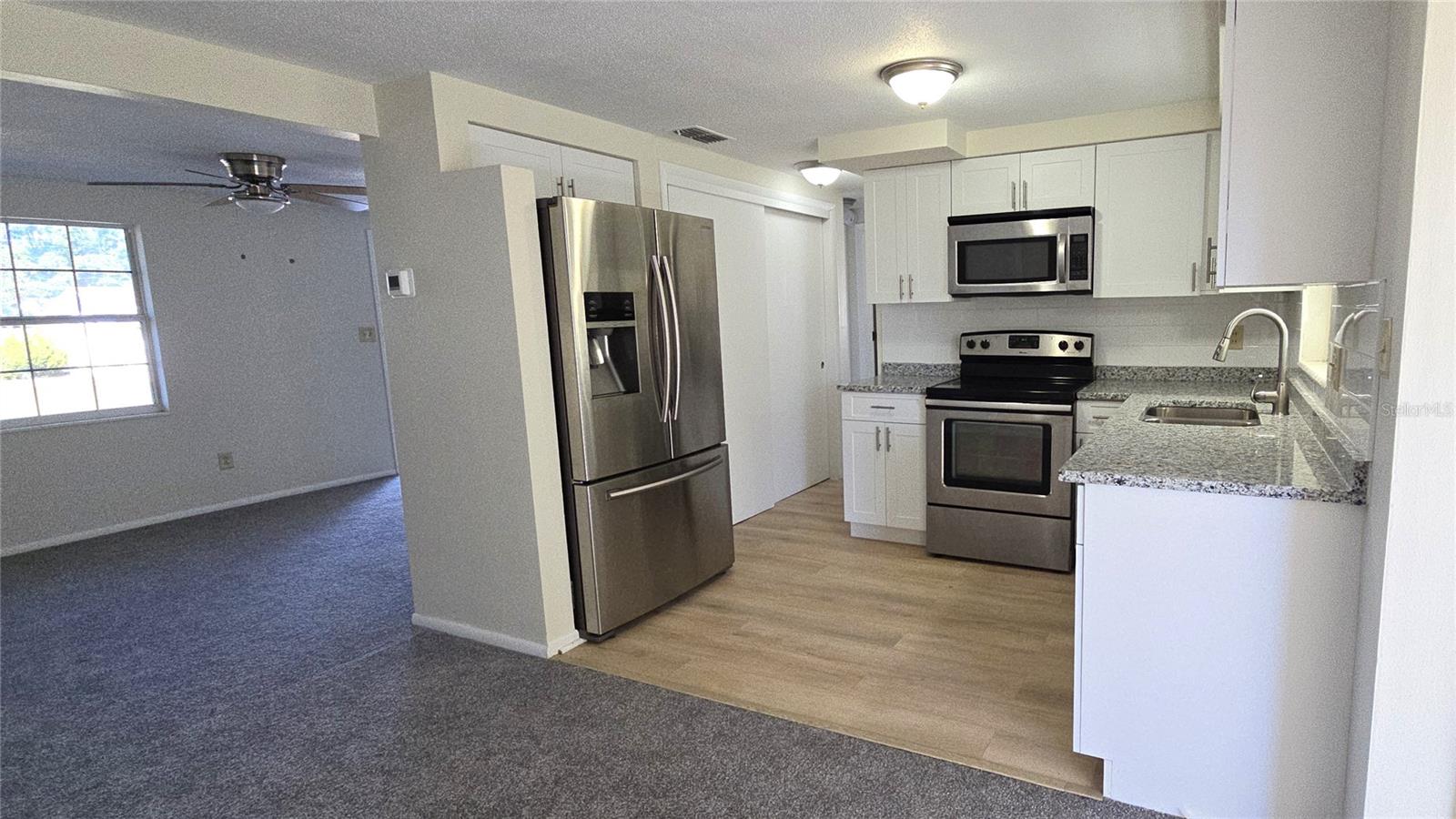 VIEW FROM DINING ROOM TOWARDS KITCHEN AND LIVING ROOM