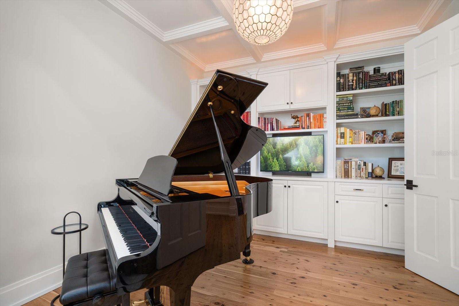 The library/office with coffered ceilings, built in bookcases and gas fireplace