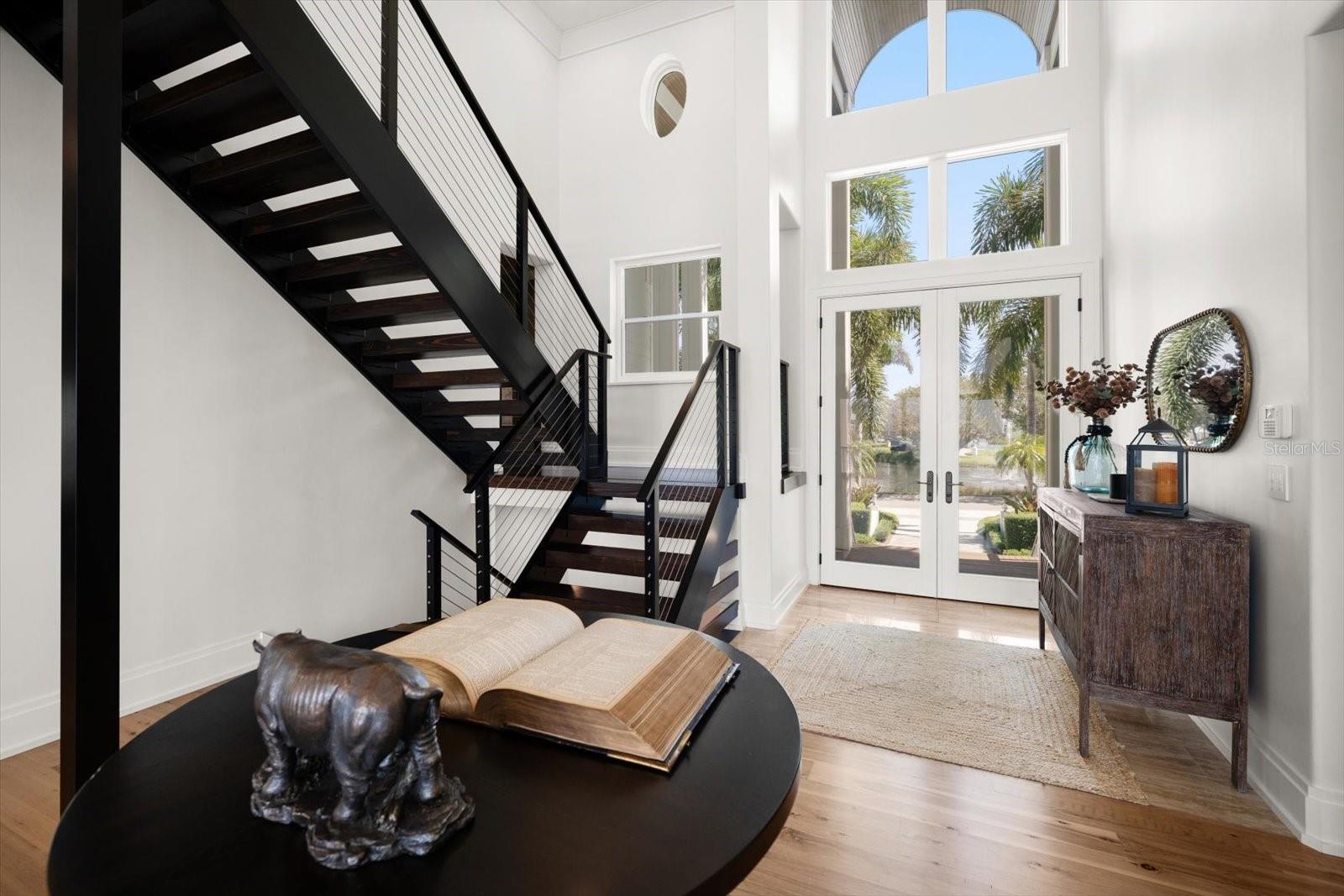 Front entry with 21' ceiling and floating staircase with stainless-steel cable railings