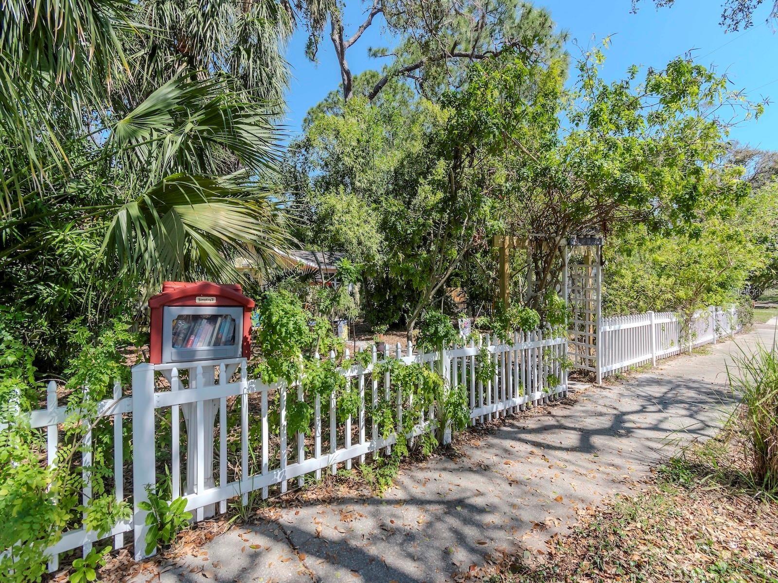 FRONT PICKET FENCE INVITING YOU TO ENTER! ALSO A SMALL LIBRARY IS LOCATED ON THAT FENCE.