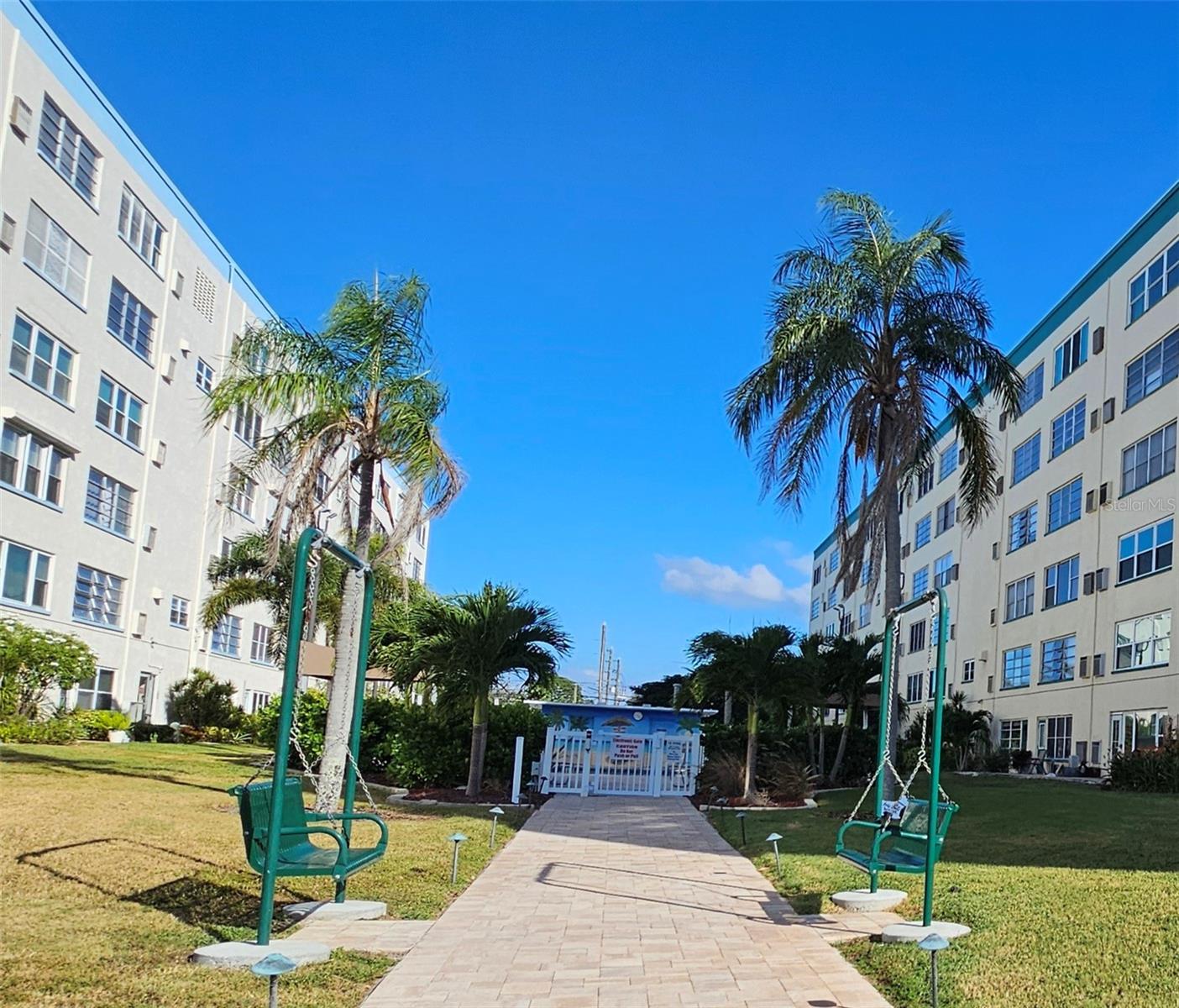 Walkway to the pool with swings to play on.