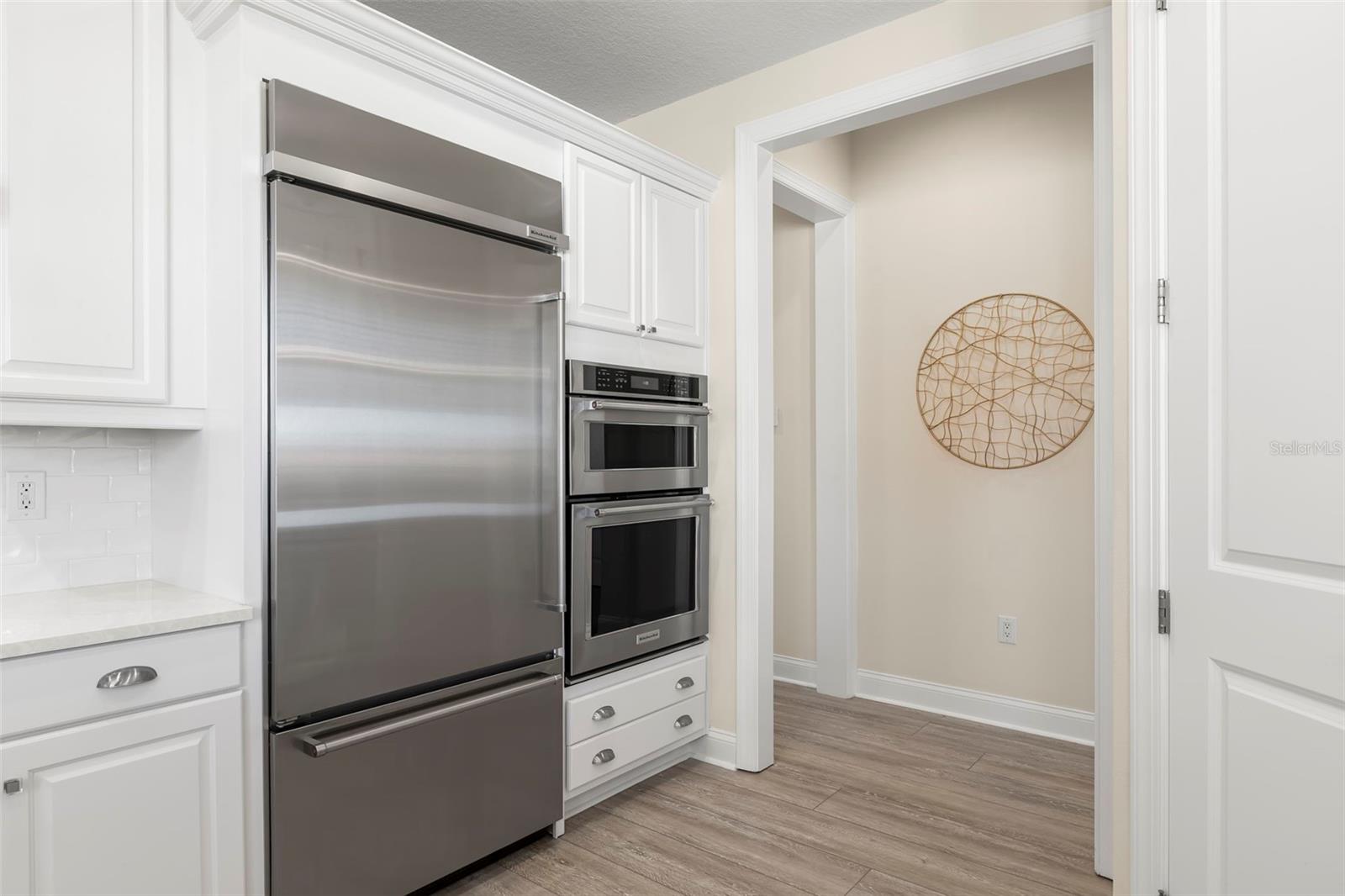 36" Kitchen-Aid refrigerator, dual ovens, pantry closet on the right.