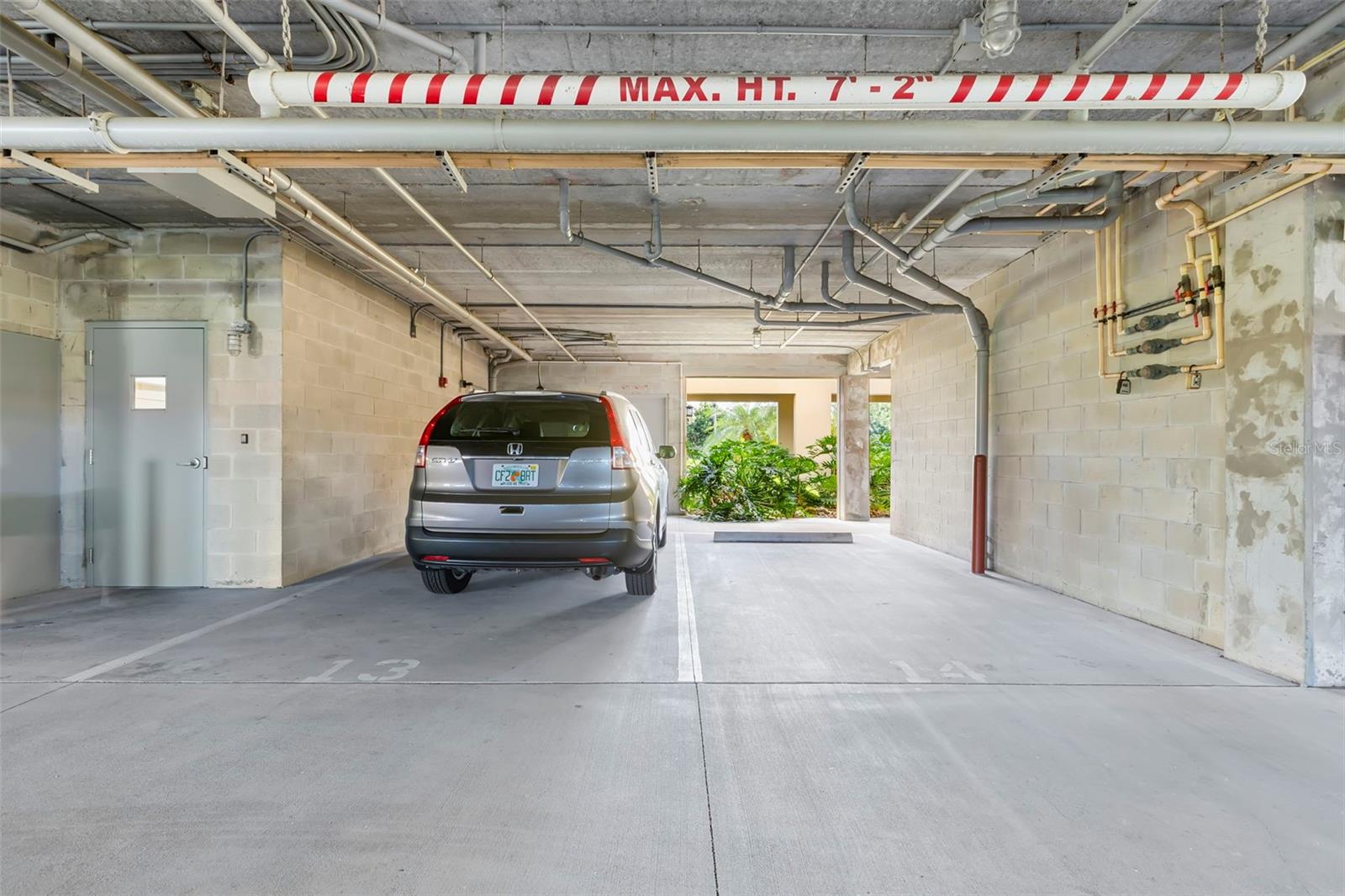Two protected side-by-side covered parking spaces, the closest parking spaces next to the elevator lobby door on the left.