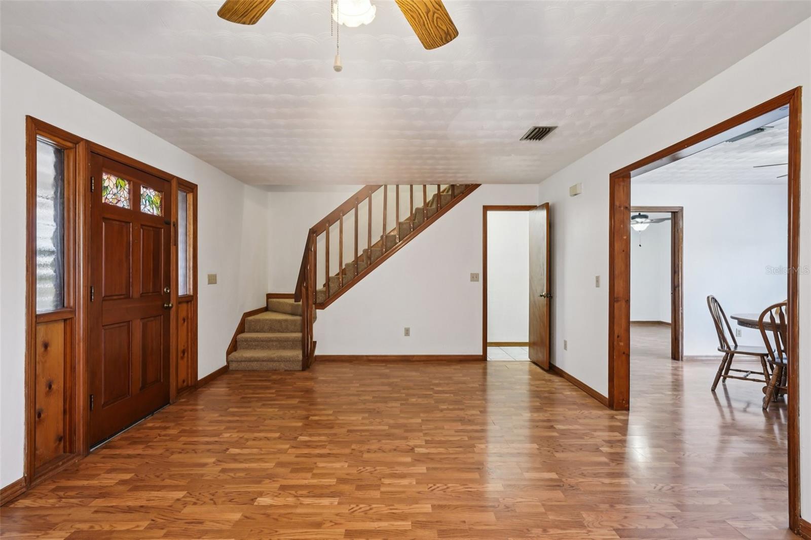 Living room with staircase, half bath & dining room