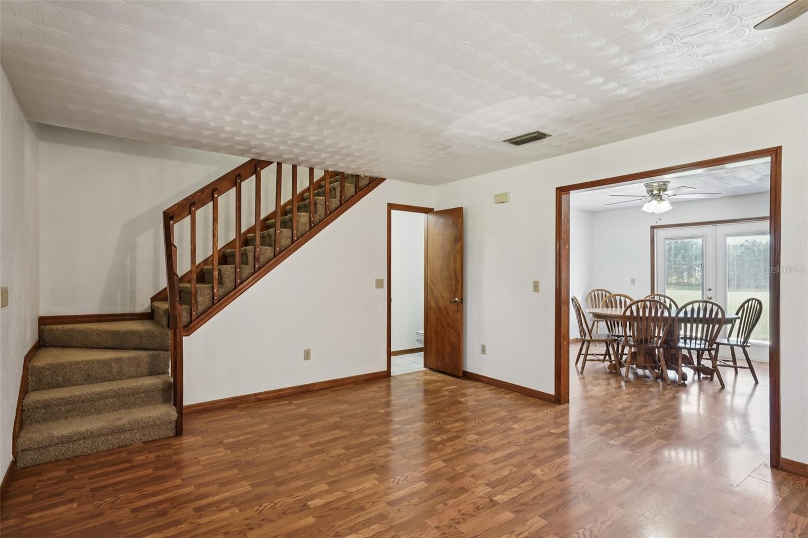 Living room with staircase, half bath & dining room