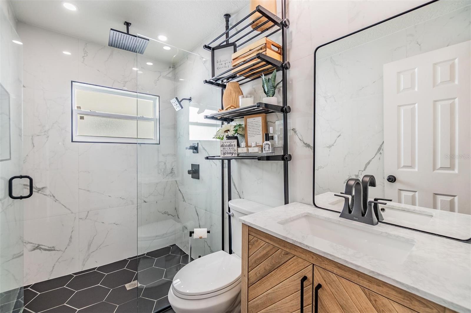 Sleek bathroom with frameless glass shower, rainfall head, and modern vanity