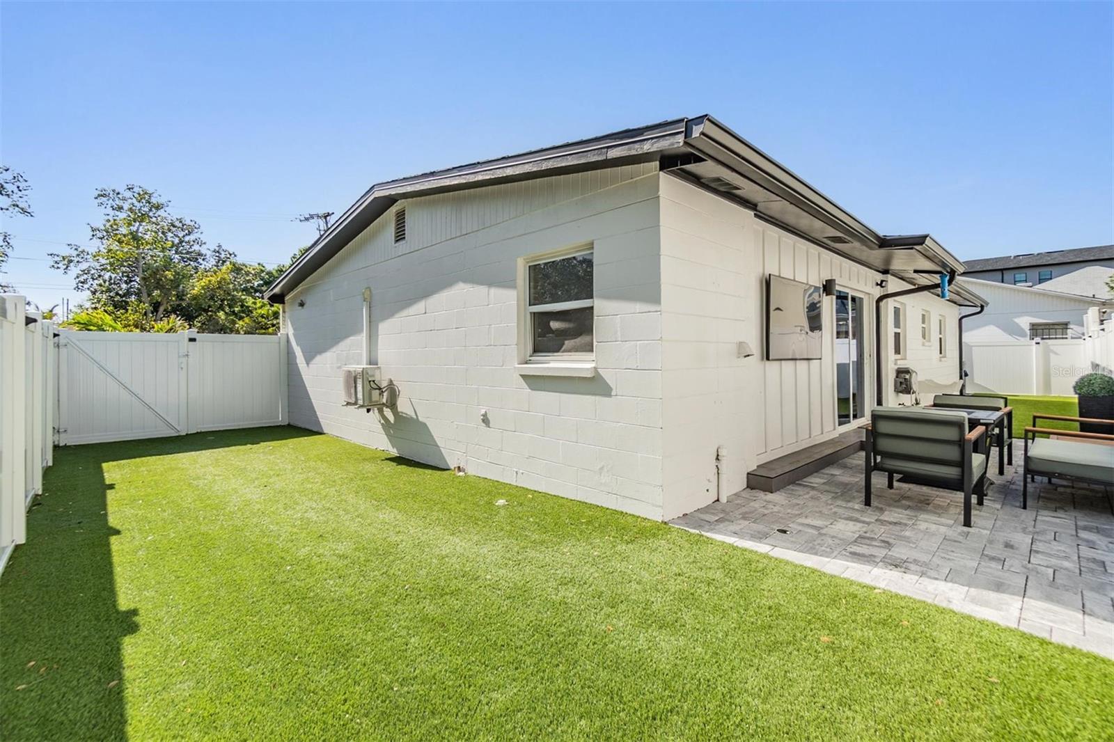 Fenced yard featuring turf and a paver patio—ideal for a poker night, weekend grilling, or enjoying the gorgeous Florida sunshine.